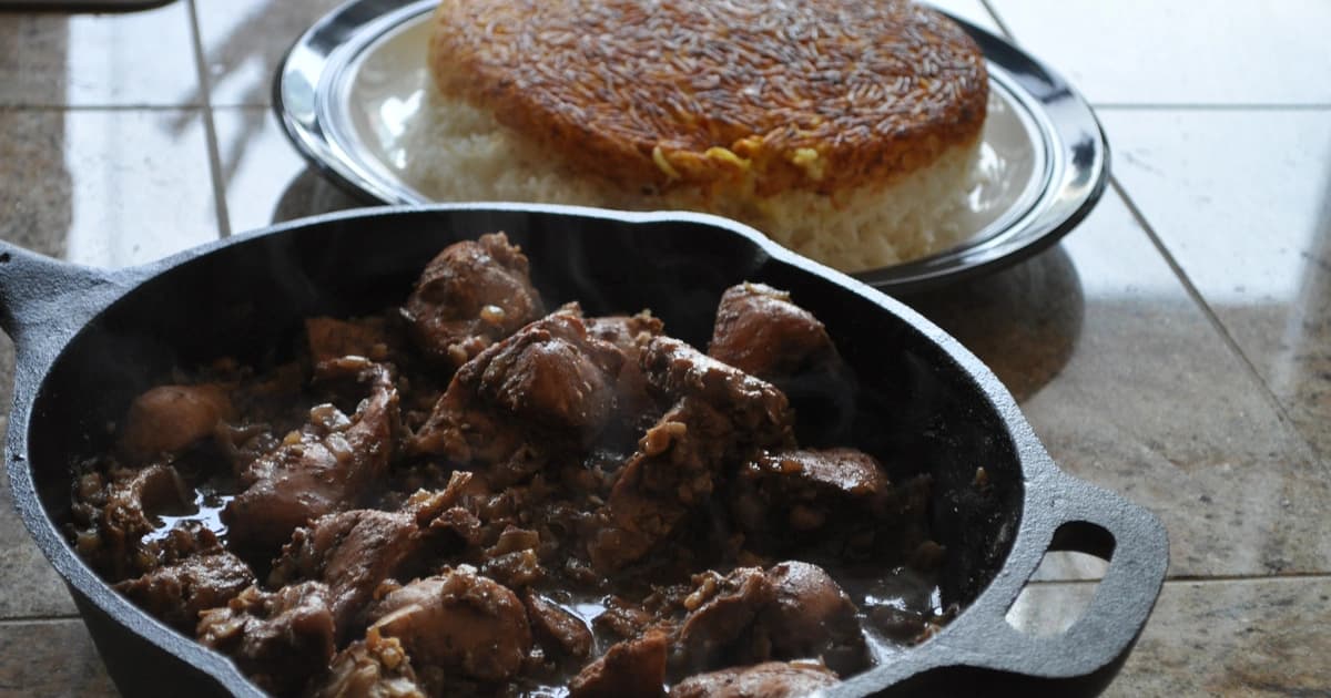 Ultimate Guide Fesenjan Persian Pomegranate Walnut Stew House OF Legends Encino Blog Feature Image Rich mahogany fesenjan stew with tender chicken in pomegranate walnut sauce garnished with fresh pomegranate arils served over saffron rice at House of Legends Restaurant Encino